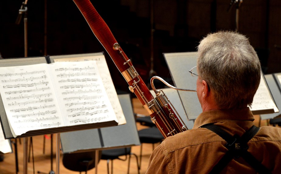 Person playing bassoon in an orchestral setting